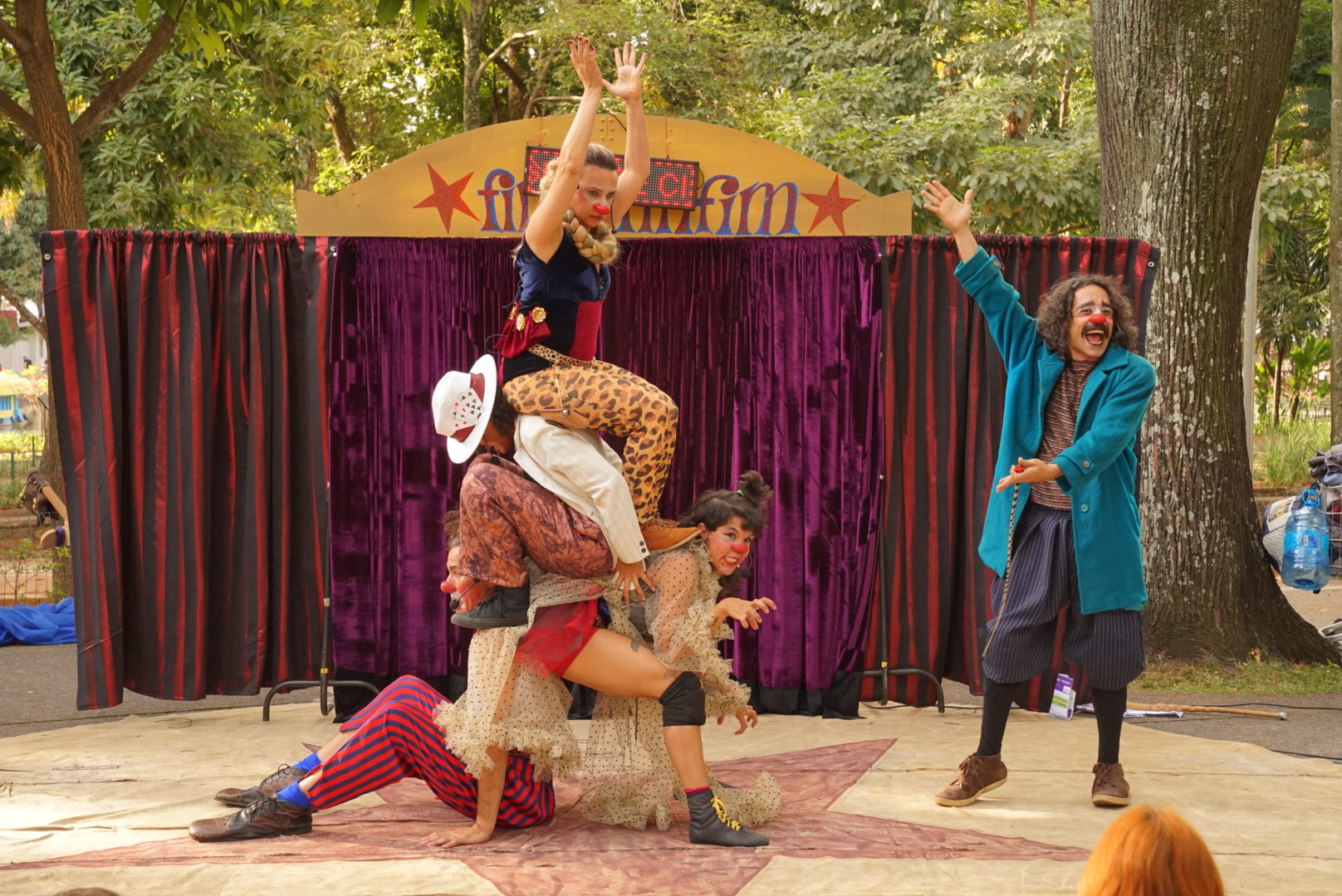 Pirâmide de artistas do espetáculo El Grande Circo Firinfinfim, letreiro do circo ao fundo